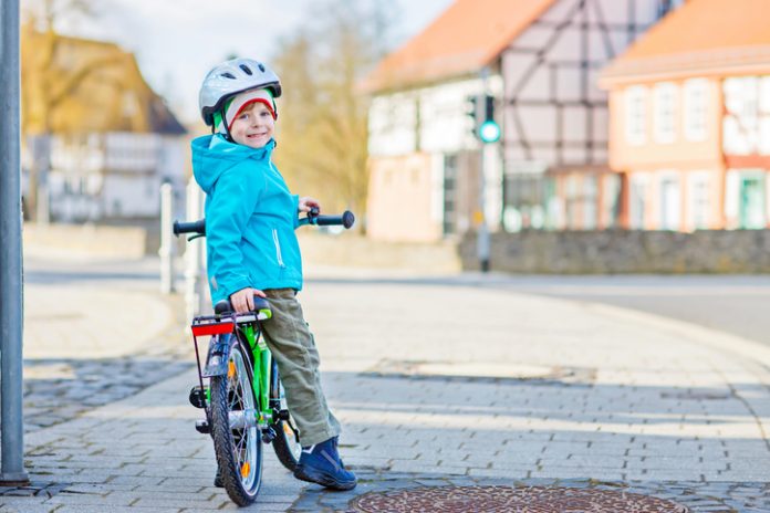 Little preschool kid boy riding on bicycle